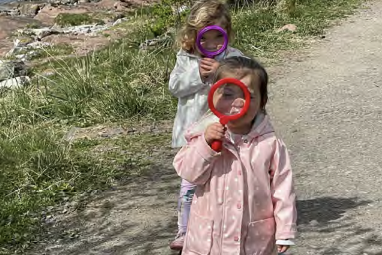 Young children exploring with magnifying glasses.